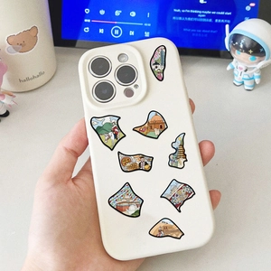 Dettaglio custodia smartphone crema con illustrazioni di viaggio e protezione lente