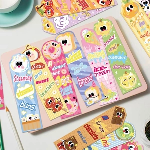 Flat lay of colorful cartoon food bookmarks on a pink desk with creative stationery props