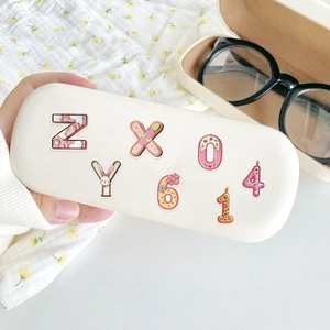 Cute cartoon animal and letter stickers on a cream rectangular eyeglass storage case