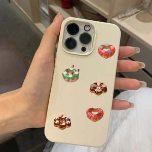 Detailed view of beige iPhone case decorated with five colorful cartoon donuts