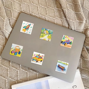 Vue détaillée de stickers de dessins animés faits main sur un ordinateur portable gris