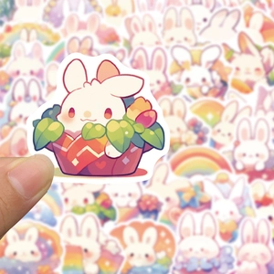 Gros plan d'un autocollant de lapin de dessin animé tenu sur une pile colorée