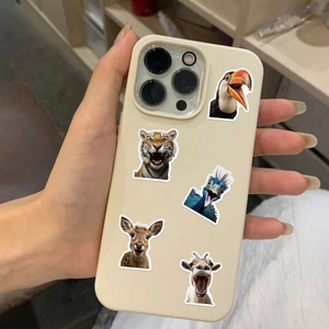Gros plan d'une coque iPhone crème décorée d'autocollants d'animaux rigolos en main