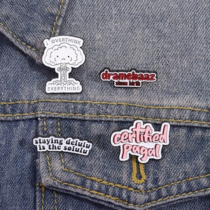 Trendige Emaille-Anstecknadeln mit lustigen Sprüchen auf einer Jeansjacke