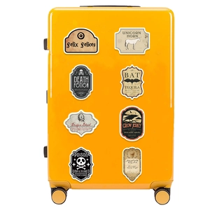 Retro gothic potion stickers shown on a bright yellow suitcase with magic themes