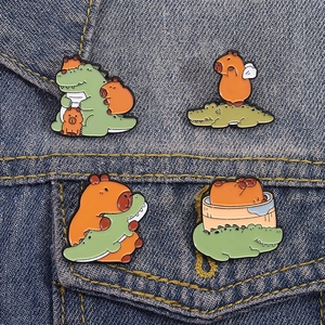 Set of four cute cartoon capybara and crocodile enamel pins on denim jacket