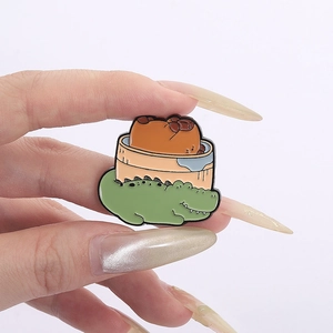 Macro view of a cute capybara and crocodile enamel pin with detailed metal craftsmanship