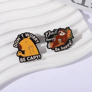 Detail of Capybara and Sloth enamel pins with positive slogans on a wavy background