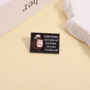 Detail of enamel pin with kiwi bird and German text Bitte Nicht Schubsen! Ich habe Bier im Rucksack