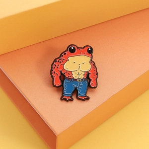 Detail shot of creative red muscle frog enamel brooch with blue jeans on a tiered stand