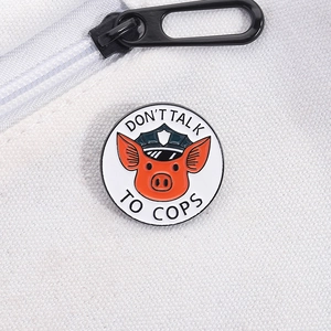 Close-up of cute pig sheriff enamel pin with Don't Talk To Cops slogan on a canvas bag