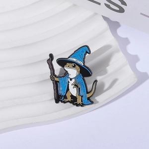 Detailed view of cartoon lizard wizard enamel pin on a white wavy textured display stand