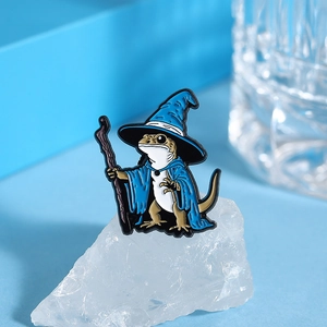 Close-up of lizard wizard enamel pin with blue cape and staff for backpack decor