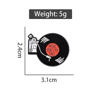 Retro vinyl record player enamel pin with Music Heals My Soul text in black and white