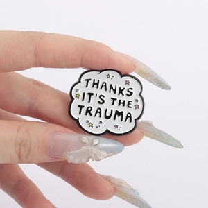 Cloud-shaped enamel pin badge featuring Thanks It's The Trauma text and star details