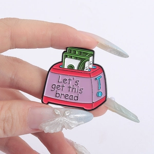 Cartoon toaster enamel pin with Let's Get This Bread text and banknote design