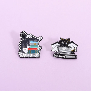 Broches en émail de dragon de dessin animé avec des dragons noirs et des livres colorés