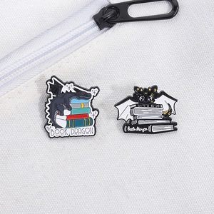 Gros plan de pin's émaillés Book Dragon colorés sur un sac à dos en toile blanche