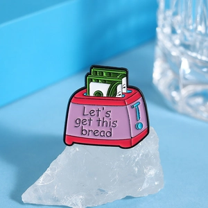 Cartoon pink toaster enamel pin with dollar bills and Let's get this bread text