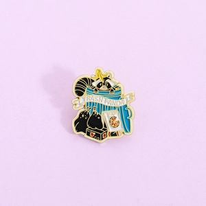 Cute Trash Panda enamel pin featuring a raccoon in a blue trash can with gold outlines