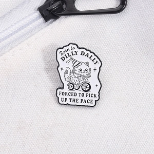 Macro view of cartoon cat on tricycle enamel pin with Dilly Dally typography detail
