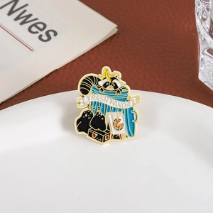 Detail of cartoon raccoon enamel pin in a trash can on a decorative ceramic plate