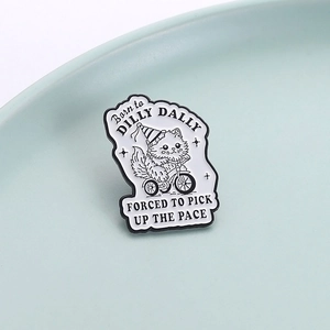 Cartoon enamel pin featuring a cat riding a tricycle with funny text on ceramic plate