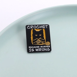 Black enamel pin with a knitting cat and 'Crochet Because Murder Is Wrong' text