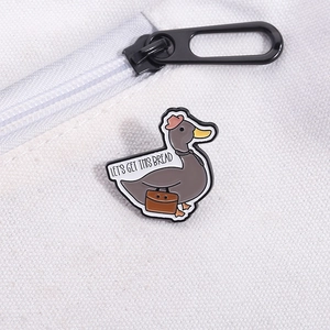 Détail du pin's canard émaillé avec texte sur la surface d'un sac en toile blanche