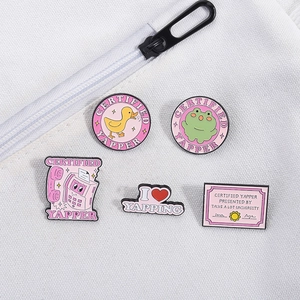 Close-up of a 5-piece enamel pin set featuring cute frogs and pink slogan badges