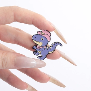 Close-up of a purple cartoon dinosaur enamel pin with a pink cowboy hat and bandana