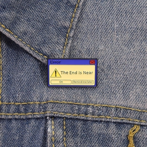 Y2K computer error message enamel pin brooch on blue denim jacket pocket detail