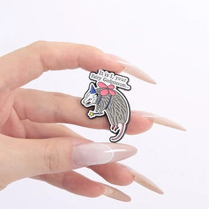 Funny fairy godpossum enamel pin with wings and wand being held against white background