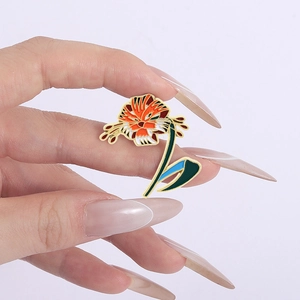 Broche en émail de lys tigré avec motif floral et rayures de tigre tenue à la main