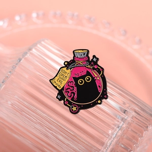 Detailed macro view of black cat potion enamel pin showing pink liquid and metal details