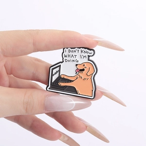 Detail of cartoon enamel pin featuring a golden retriever with a laptop and fun text