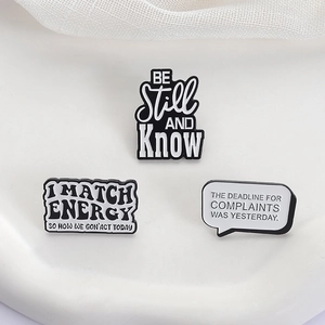 Macro detail of enamel pins with quotes on white ceramic plate and mesh background