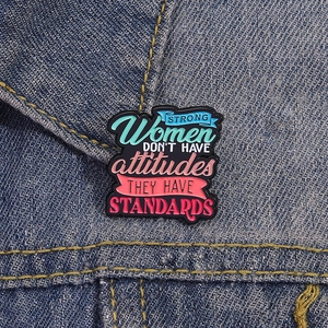 Empowering enamel pin with motivational quote on a blue denim jacket for women