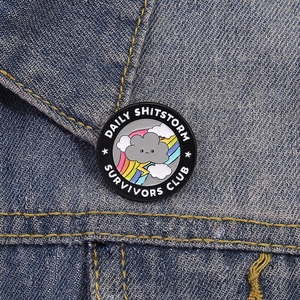 Badge en émail Daily Shitstorm Survivors Club sur veste en jean avec nuage et arc-en-ciel