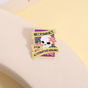 Macro detail of enamel skull pin with floral motifs on stone pedestal background