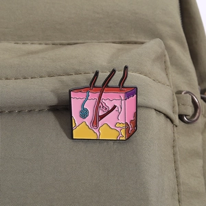 Detailed skin tissue anatomy enamel pin showing layers and hair follicle on green bag