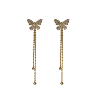 Detail of gold butterfly tassel earrings with sparkling cubic zirconia and long chain fringe