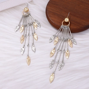 Close-up of long metal tassel earrings with gold and silver leaf pendants on plush background