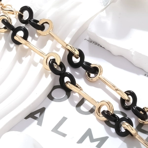 Détail du collier à maillons géométriques dorés et noirs avec finition polie
