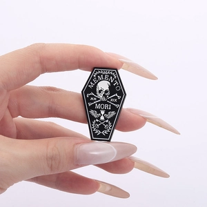 Gothic black enamel coffin pin featuring skull, winged hourglass and Memento Mori text