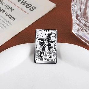 Macro shot of The Witch tarot card enamel pin with black cat and lunar phases detail