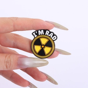 Macro view of a punk enamel pin with yellow radiation symbol and I'M RAD lettering