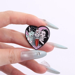 Detalle macro del pin esmaltado en forma de corazón con personajes de películas de terror