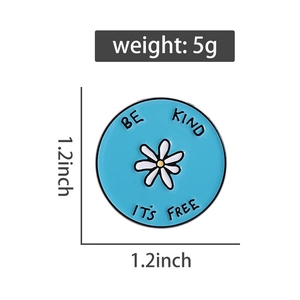Detail view of round blue enamel pin with daisy and Be Kind text, 5g weight measurement