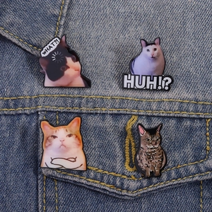 Funny cat meme pin badges on blue denim fabric showing detailed enamel craftsmanship